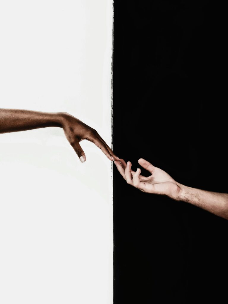 Symbolic image of two hands reaching toward each other, representing unity and diversity.